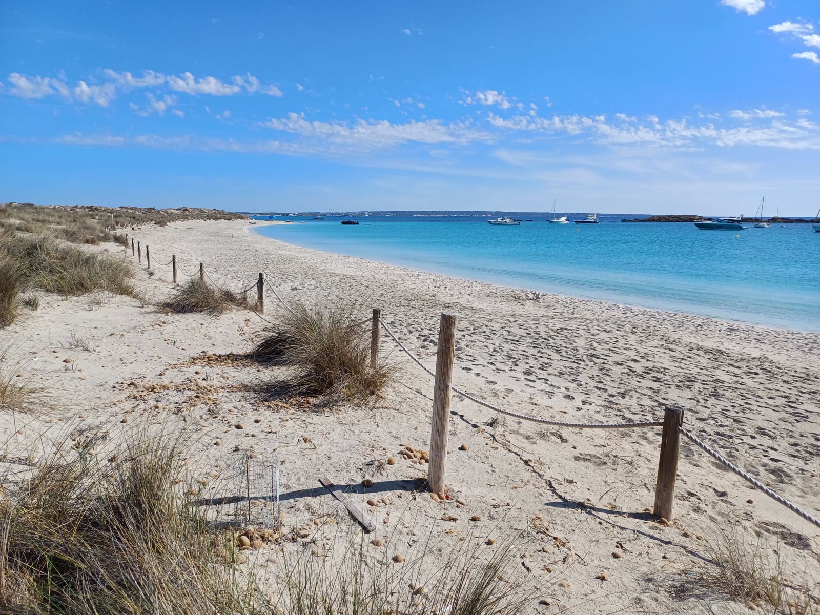 Playa tranquila de Formentera con barcos fondeados