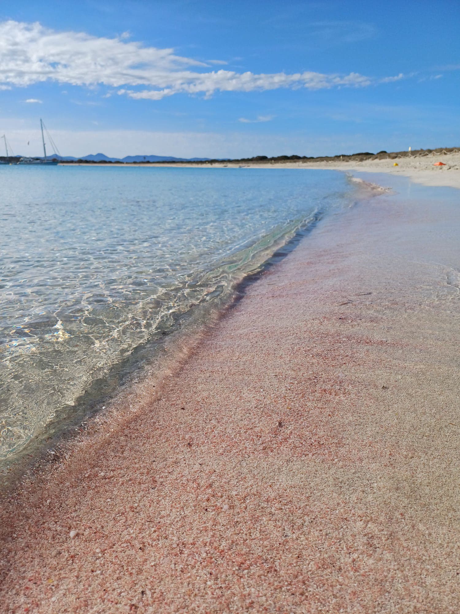 Arena rosa y agua clara y poco profunda en Formentera