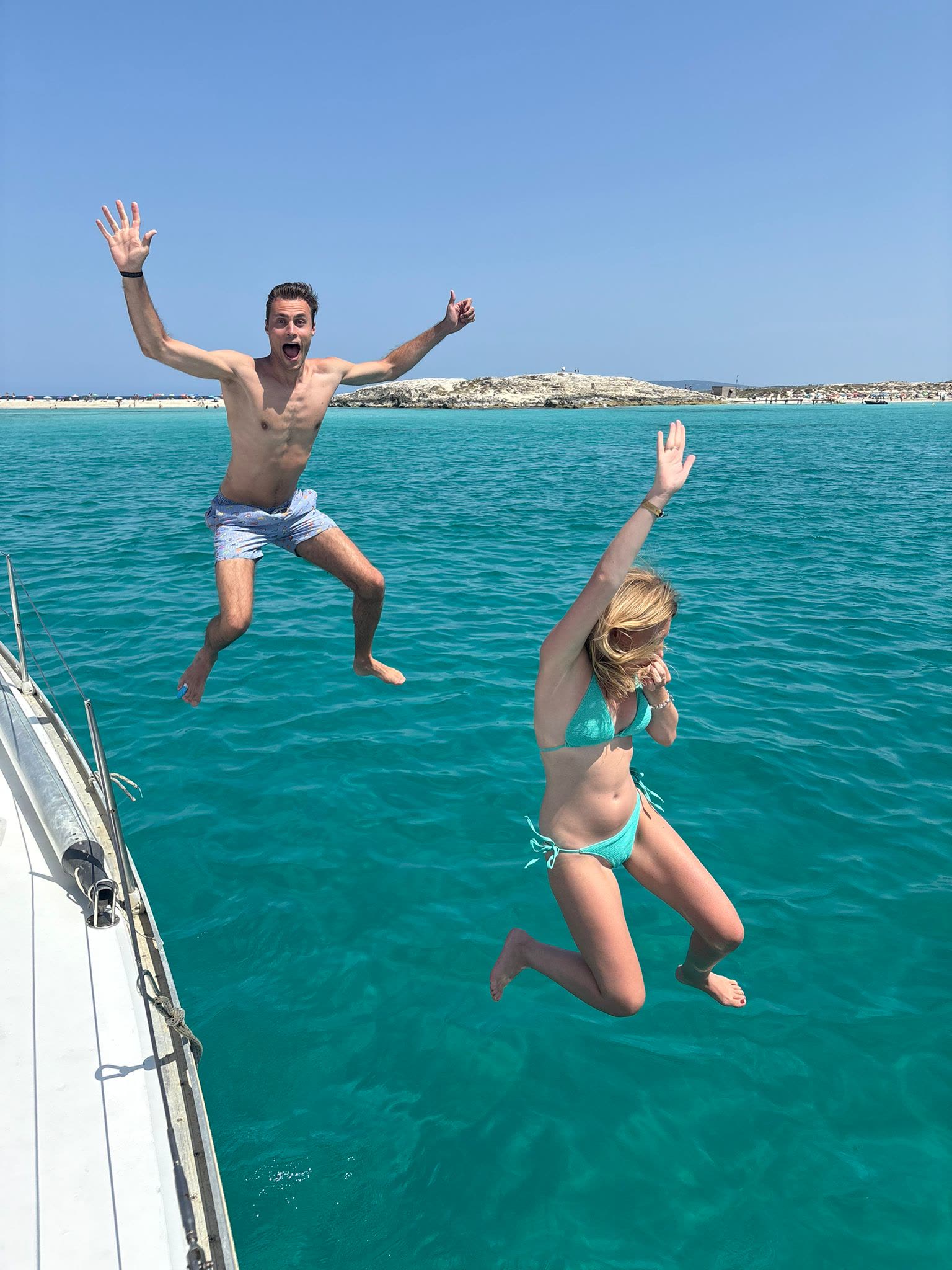 Invitados saltando del velero al agua turquesa de Formentera