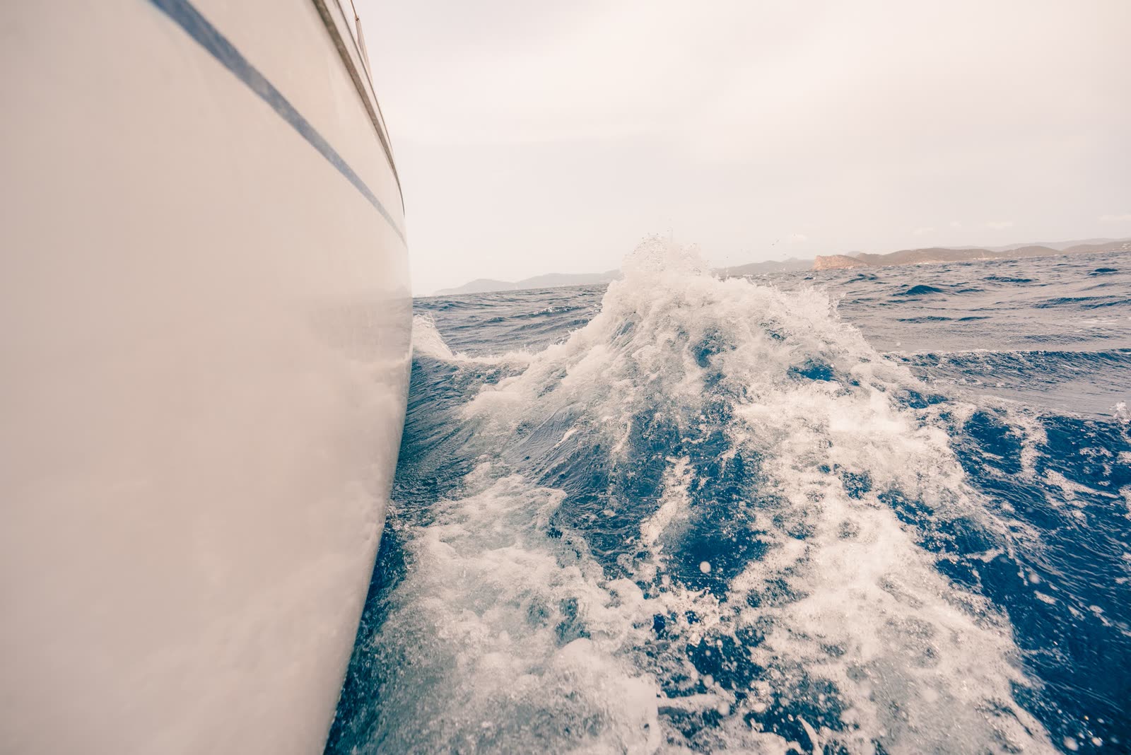The bow of a sailboat moving through open water near Ibiza