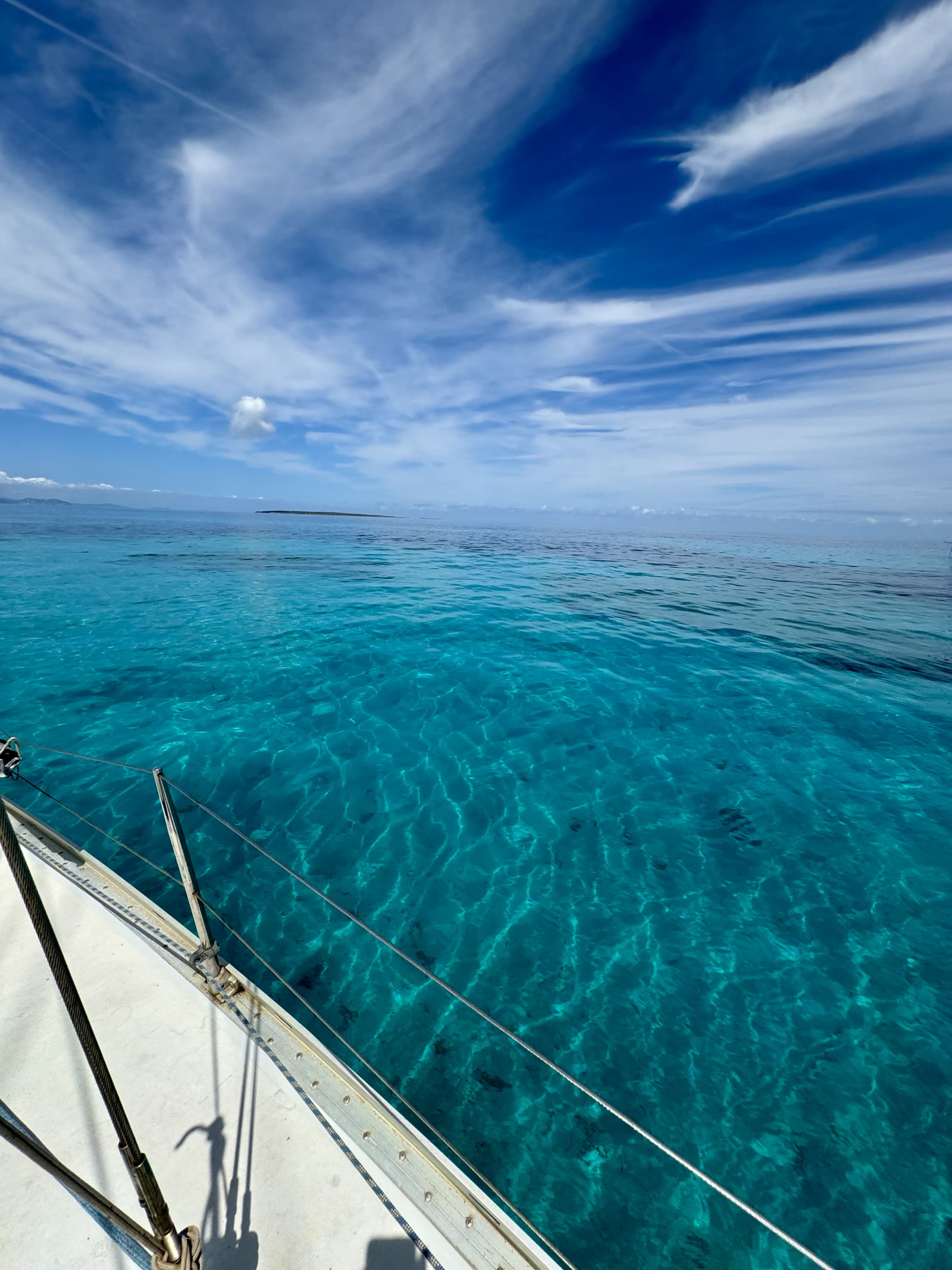Turquoise water seen from the deck of a sailboat between Ibiza and Formentera